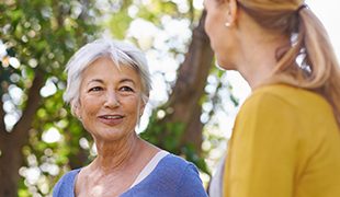 Senior woman talking to another woman funeral plans uk