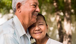 Couple happily standing close to each other embracing planning your own funeral