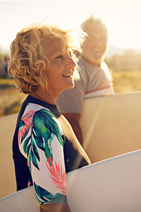 Mature lady holding a surf board cheap funeral plans