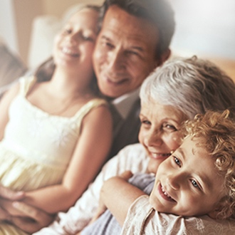 Three generations on sofa together, looking happy funeral plans