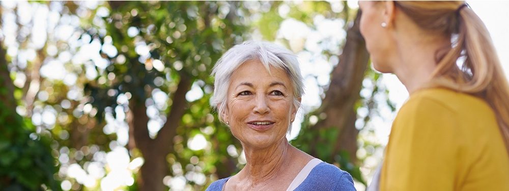 Senior lady chatting with a lady in a woodland funeral plans uk