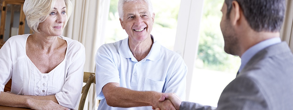 Couple shake hands with a business man funeral plans